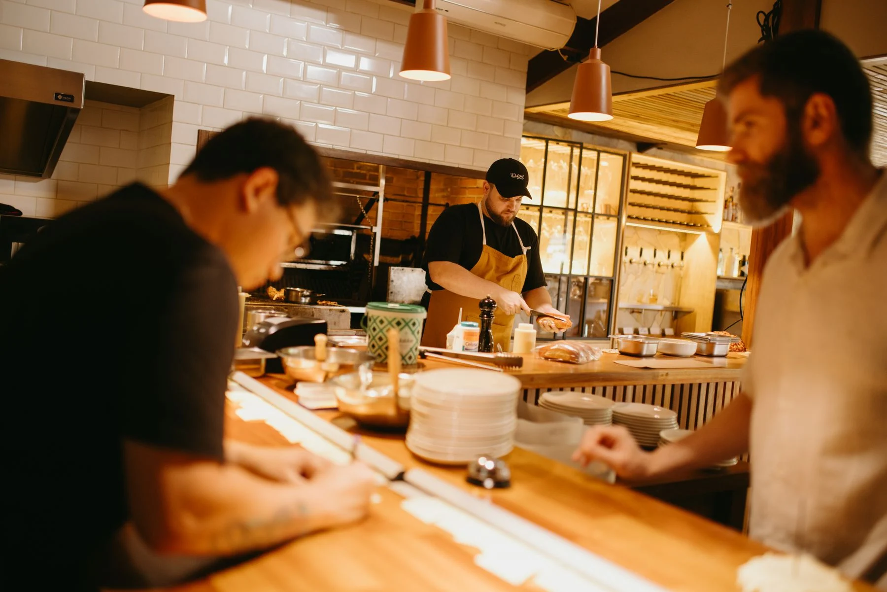 Three chefs working together in a professional restaurant kitchen