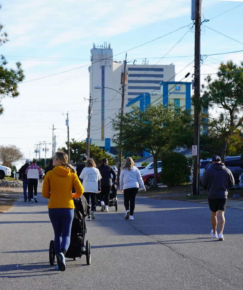 Neighbors and a stroller head down the street on race morning.