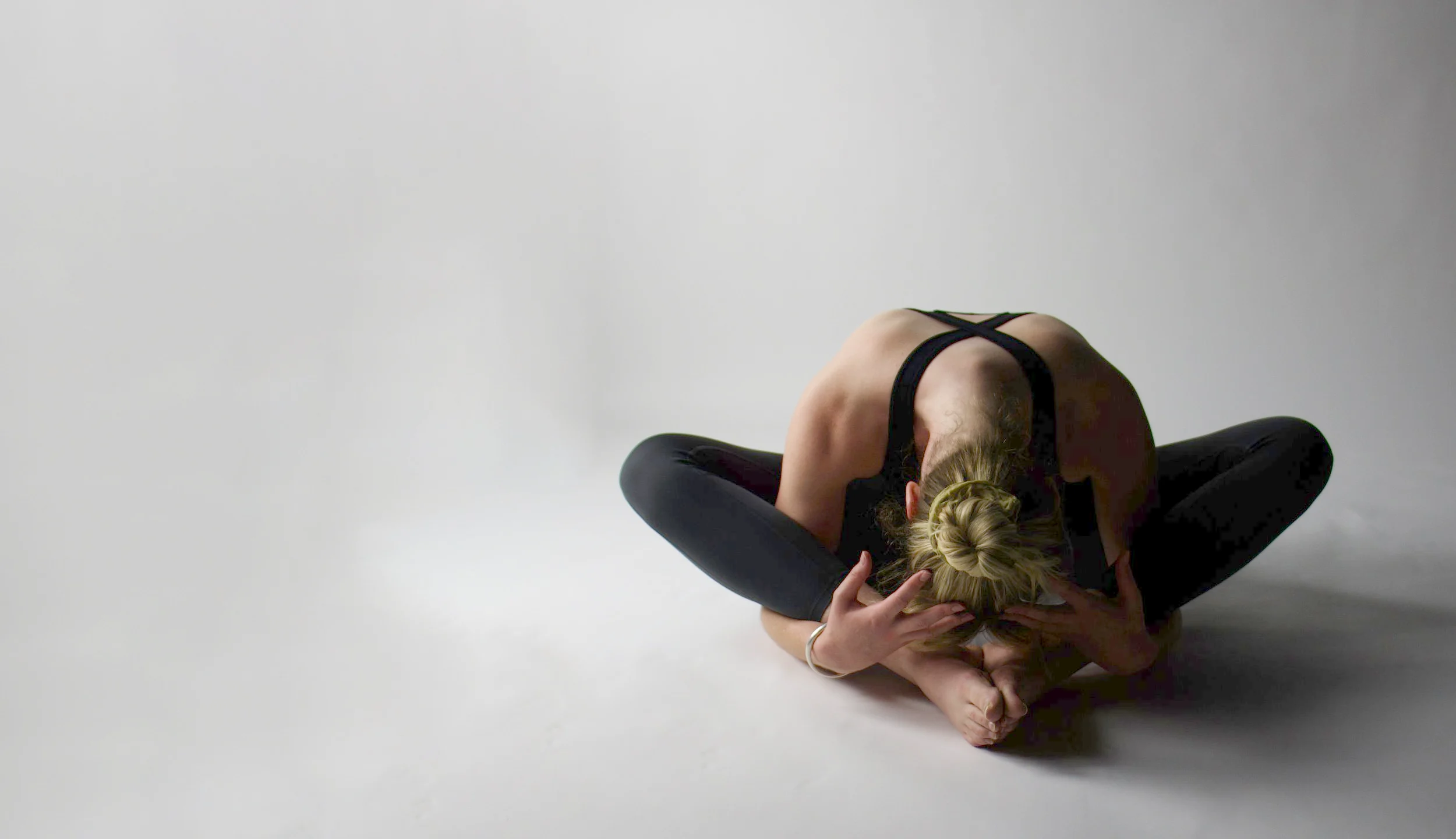 A RebelStudio student in a seated forward fold