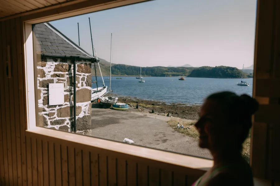 Portree Harbour and moored sailboats seen through the sauna window