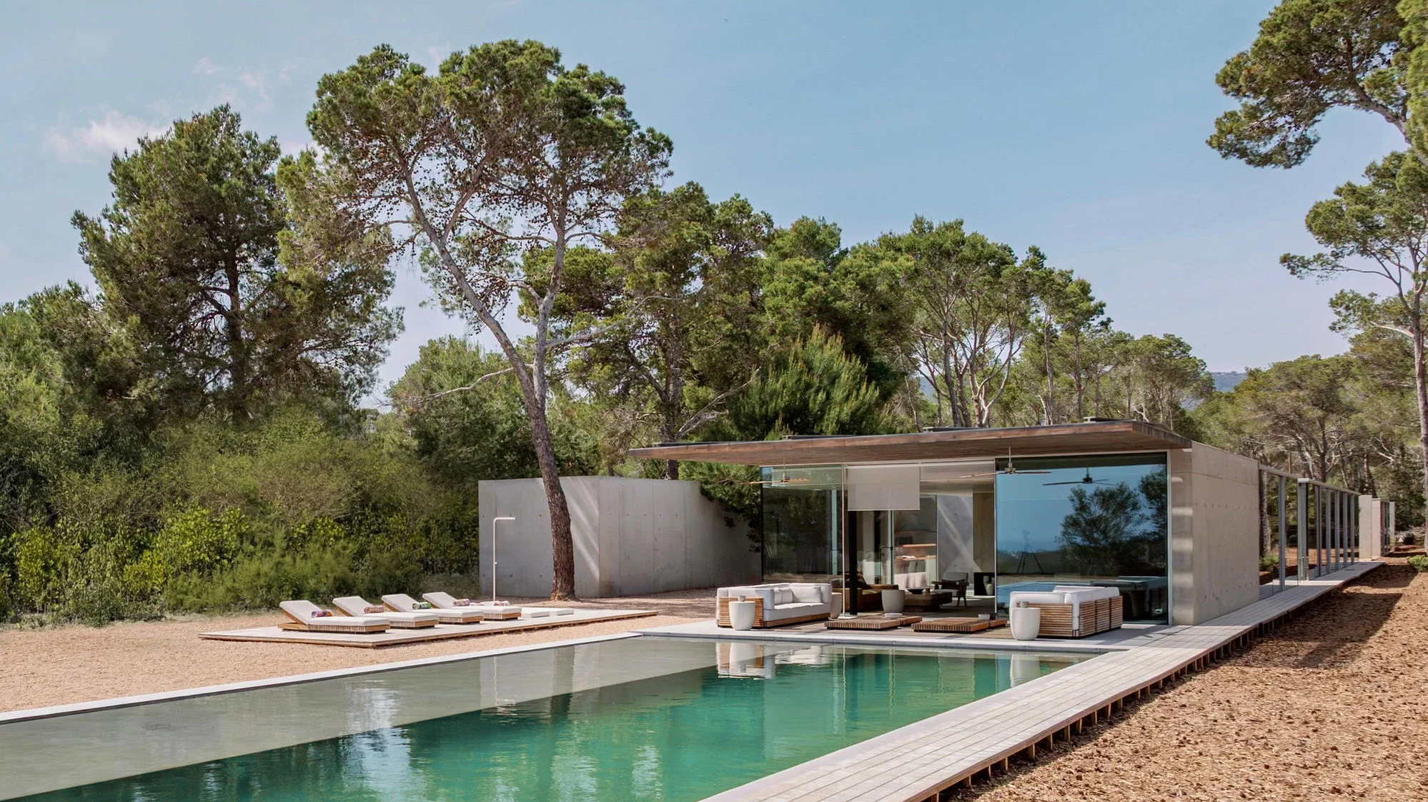 Can Fibonacci's glass-walled house and swimming pool surrounded by pine trees in Ibiza