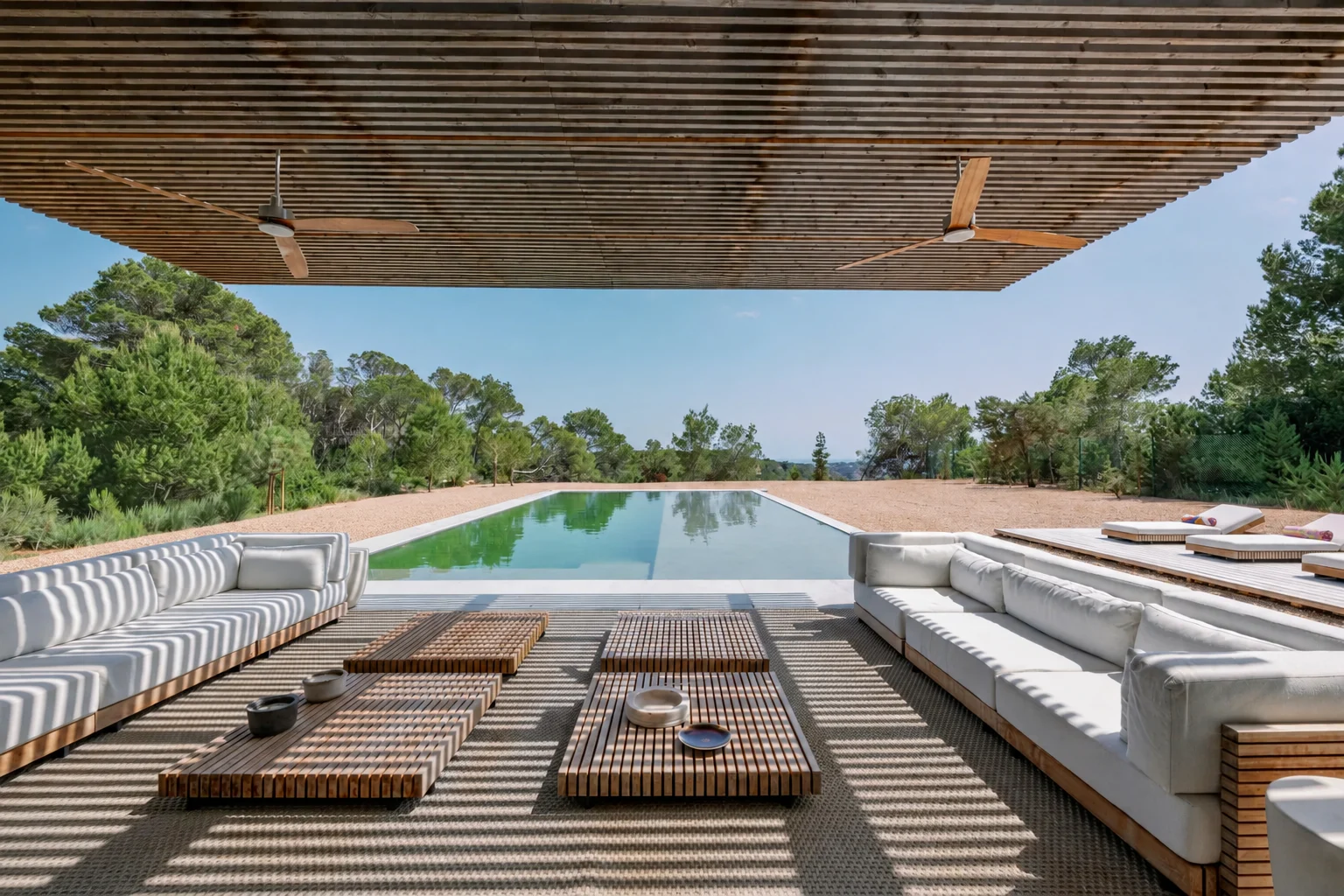 Shaded lounge under timber pergola, looking south over the pool towards Formentera.