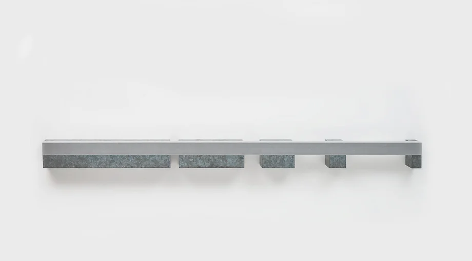 Donald Judd's horizontal Progression sculpture against a pale wall