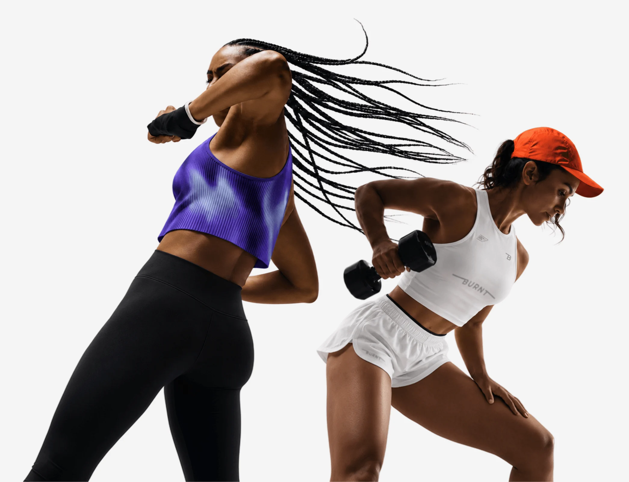 Two women training, one throwing a punch in a purple crop top and one lifting a dumbbell in an orange cap