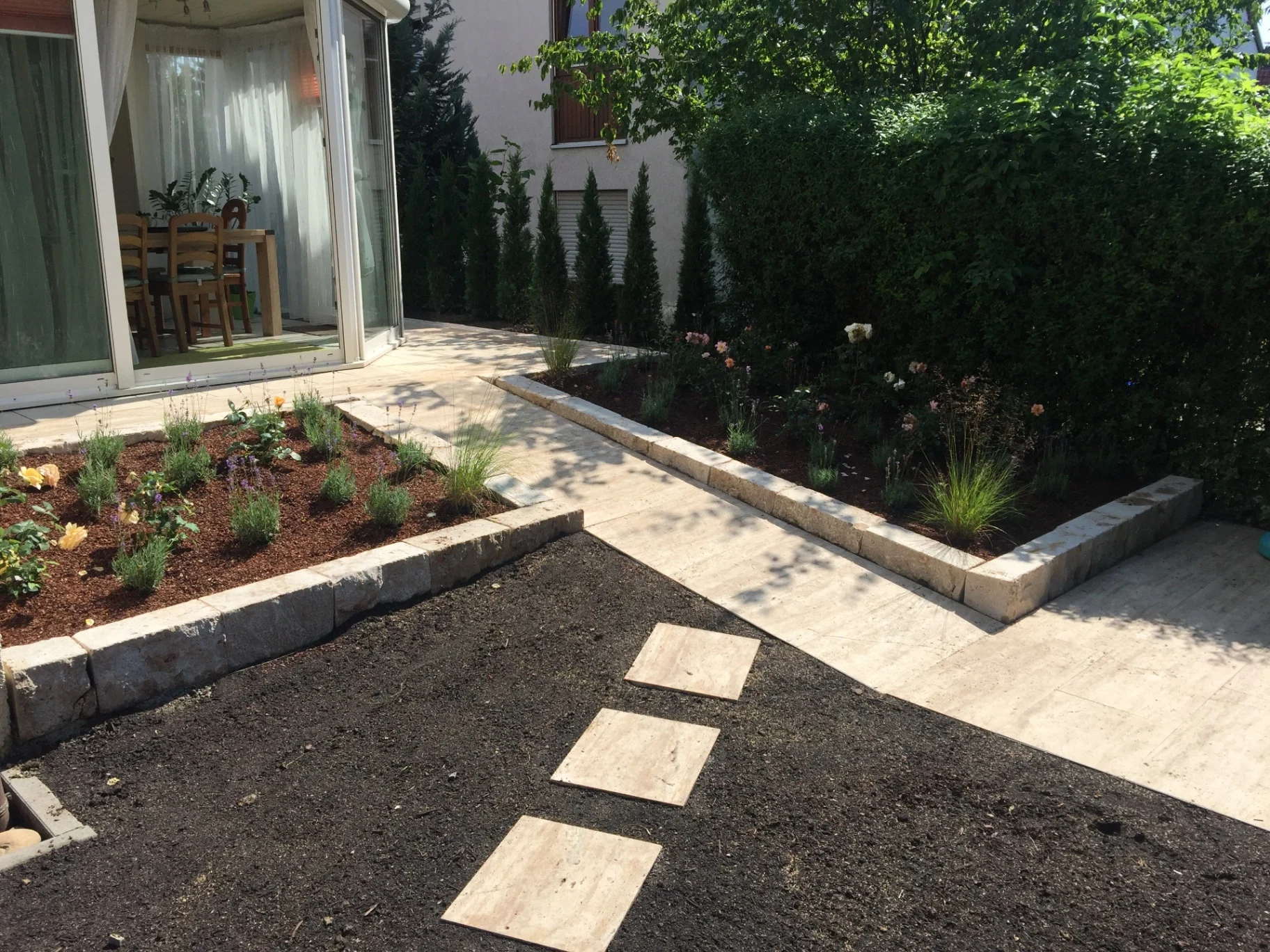 Gestalteter Garten mit Beet, Weg und Terrasse