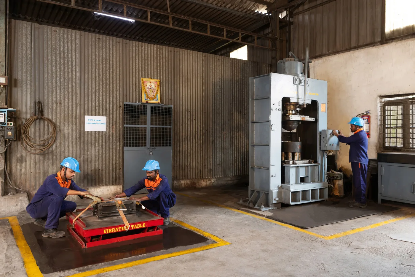VRL operators using moulding equipment and a vibrating table