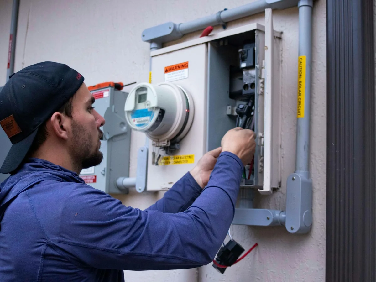 Electrician working on exterior electrical equipment