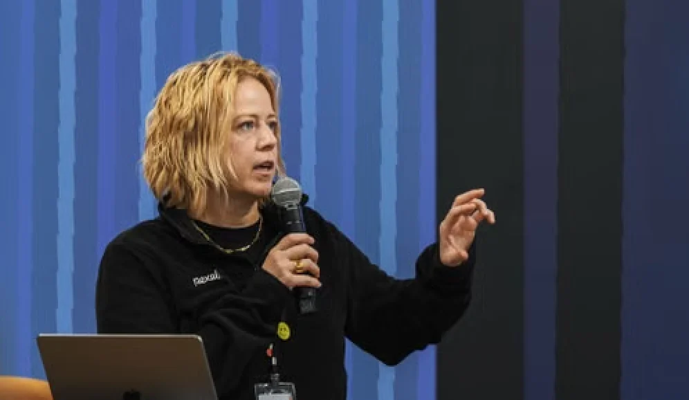 Speaker presenting on stage with a microphone