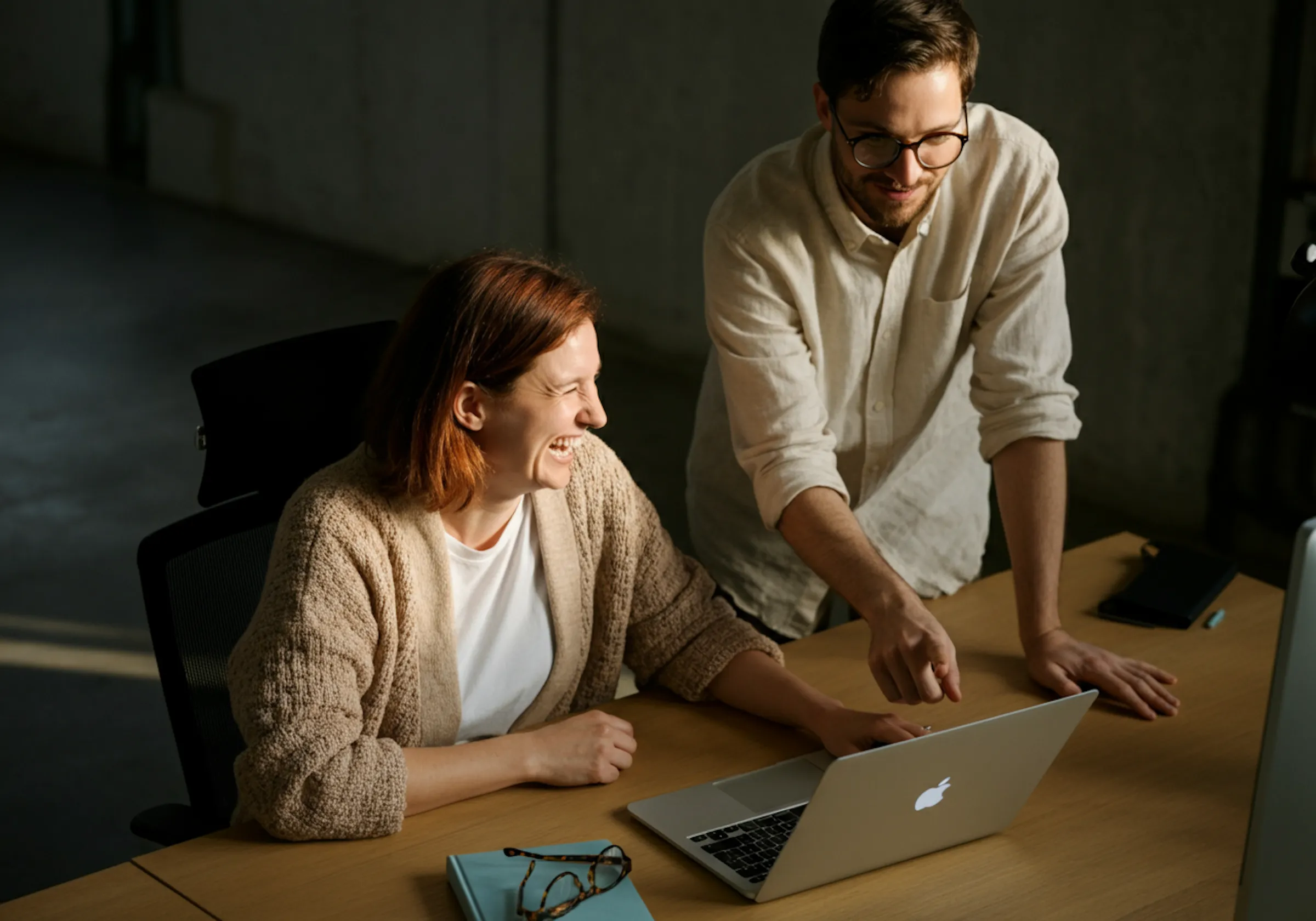 Two colleagues collaborating around a laptop