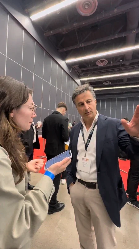 Marco Buchbinder in conversation with an attendee at a conference