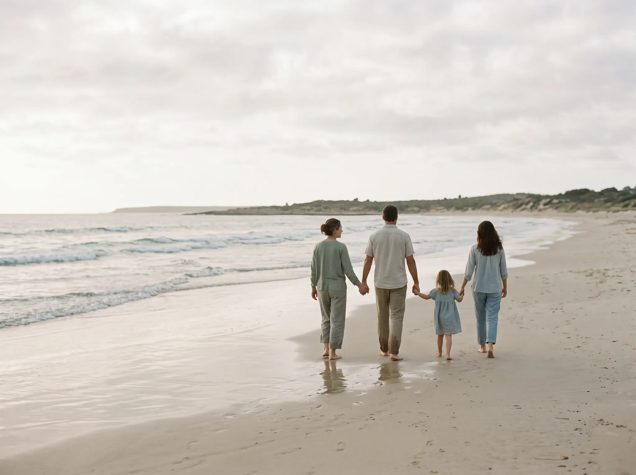 A family walking together as evening light falls on the beach