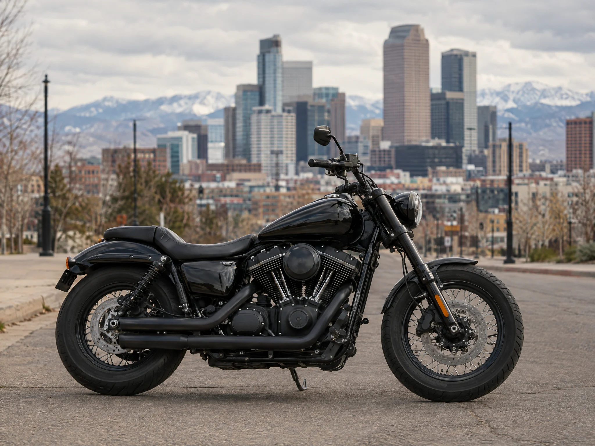 Black motorcycle parked with the Denver skyline behind