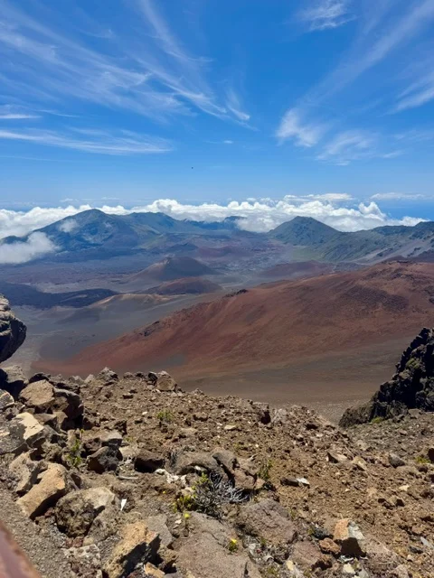 Red and brown volcanic craters at Haleakalā under a blue sky