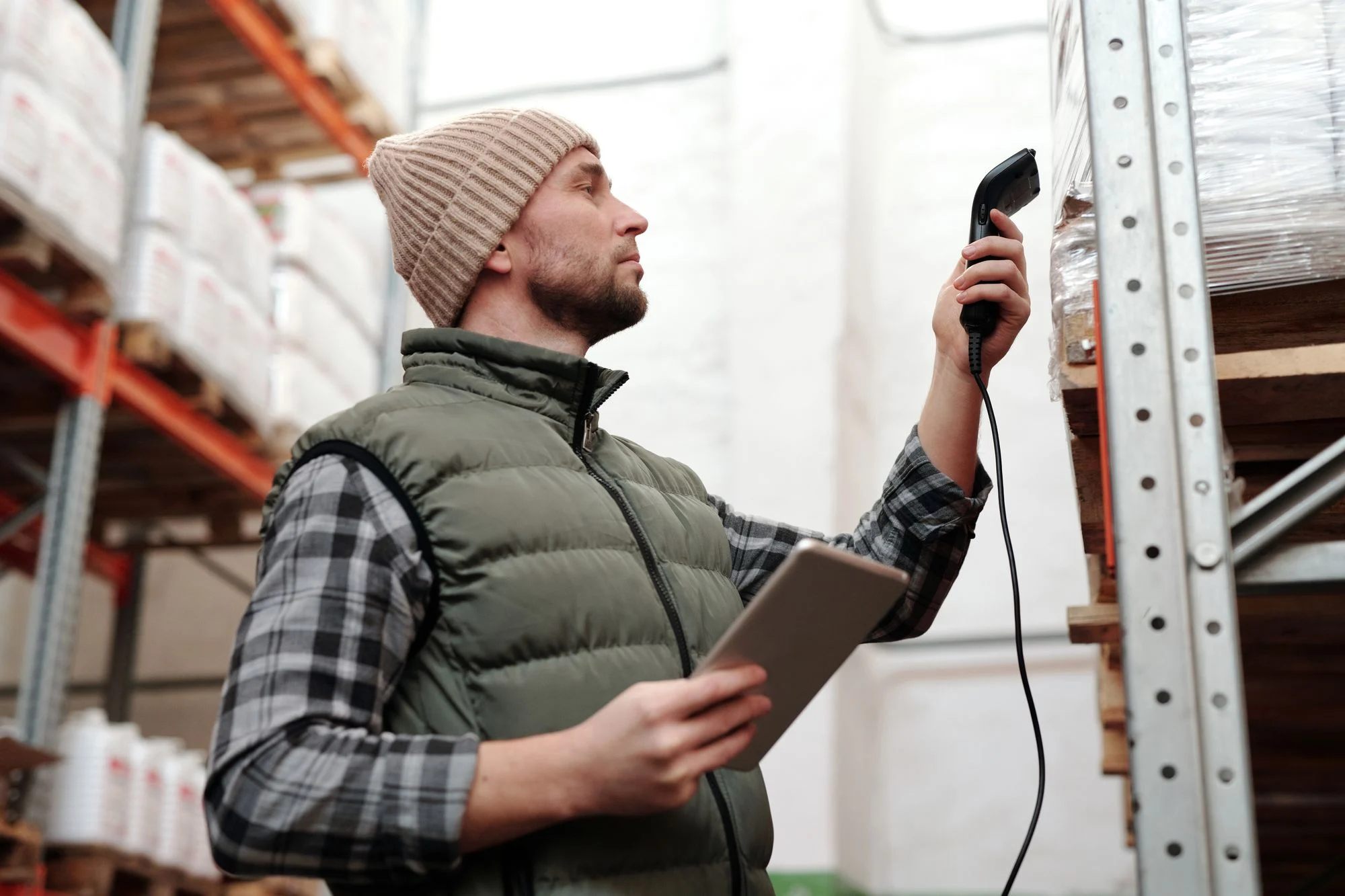 Warehouse team member scanning stock with a tablet in hand
