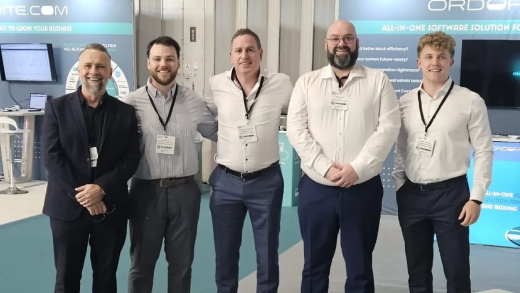 Five members of the Ordorite team standing in front of the Ordorite stand at a trade show