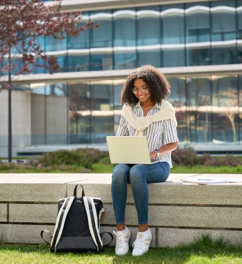 Student using a laptop outdoors on a school campus
