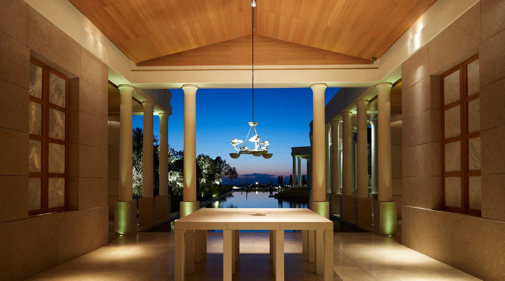 Amanzoe lobby, stone columns and reflecting pool at dusk