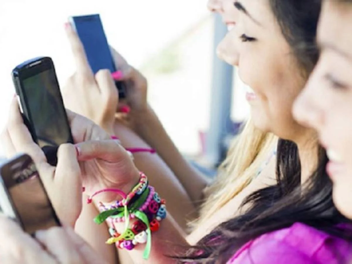 Adolescentes utilizando teléfonos móviles y redes sociales