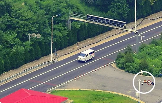 Closer aerial view of a van on a road and a roadside sign