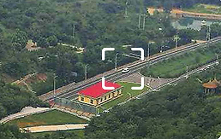 Wide aerial view of a hillside road with a framed target area