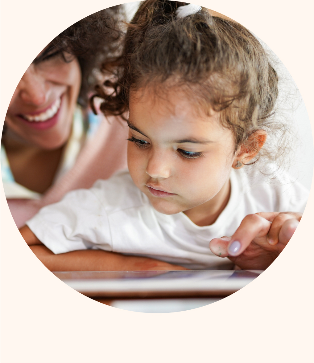 A parent and young child looking at reading material together