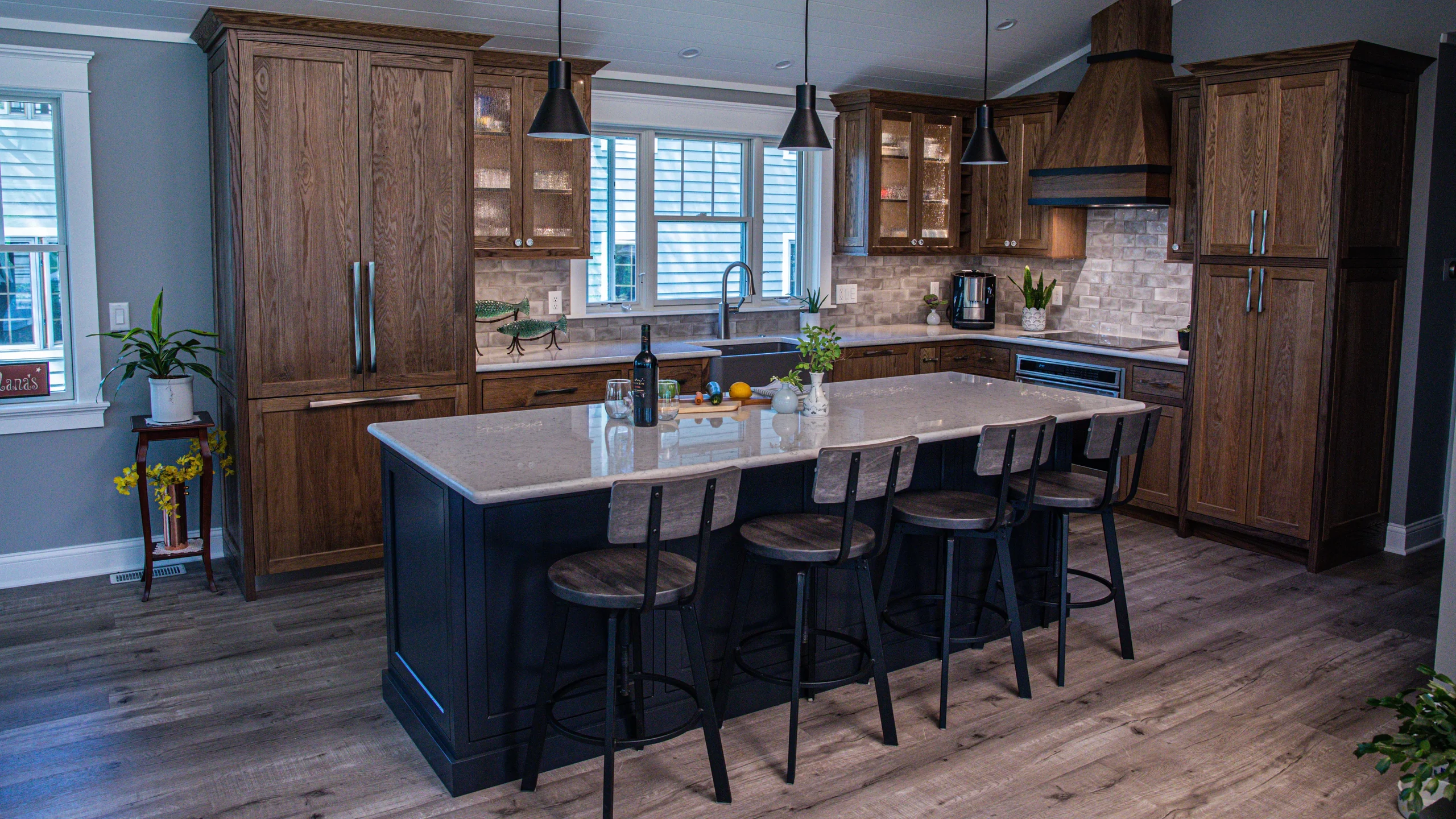 Aged oak kitchen with a deep navy island and vaulted shiplap ceiling at the Cedar Point Residence