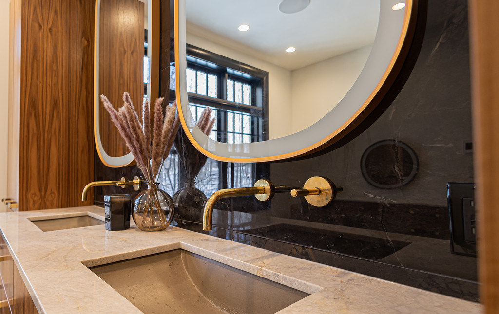 Walnut vanity with brass fixtures and black stone